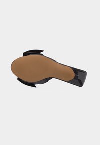 Μαύρο παπούτσι με τακούνι από γυαλιστερό δέρμα σε σχήμα τετράγωνης μύτης και ταμπά σόλα, με θέα από κάτω σε λευκό φόντο.