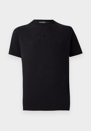 T-shirt in cotone nero con collo tondo, caratterizzato da un logo ricamato in rilievo "KARL LAGERFELD" sul petto. Maniche corte e dettaglio testurizzato.