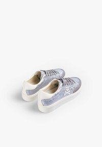 Aksamitne szare sneakersy z białymi gumowymi podeszwami, z szarymi sznurówkami i białym logo po boku. Gładka tekstura i zaokrąglony kształt.