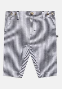 Ριγέ σορτς σε ναυτικό μπλε και άσπρο, φτιαγμένα από ελαφρύ ύφασμα. Διαθέτουν κουμπωμένη μέση, δύο πλαινές τσέπες και γυριστό στρίφωμα.