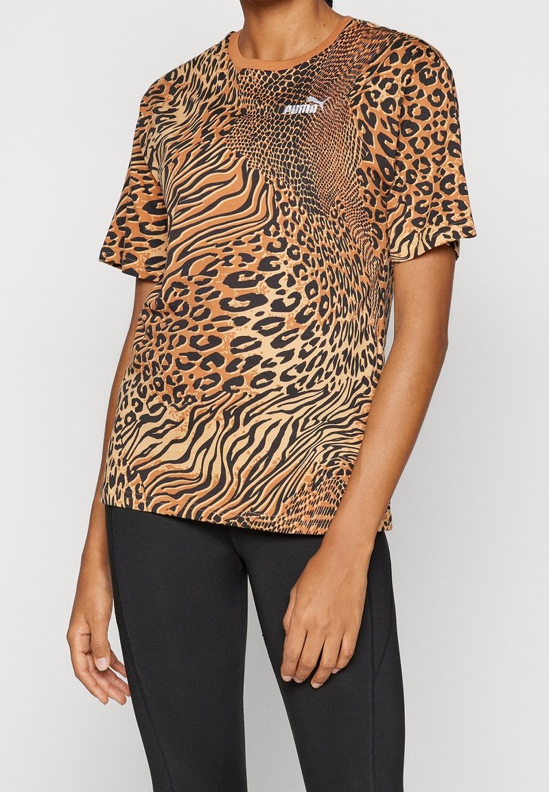 T-shirt med leopardmønster i nuancer af brunt og sort, korte ærmer, rund hals, lavet af blødt stof, med et lille logo på brystet.