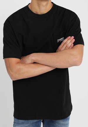 Sort bomulds-t-shirt med rund halsudskæring, korte ærmer og en venstre brystlomme med et lille "Tommy Jeans"-logo i rød og hvid.
