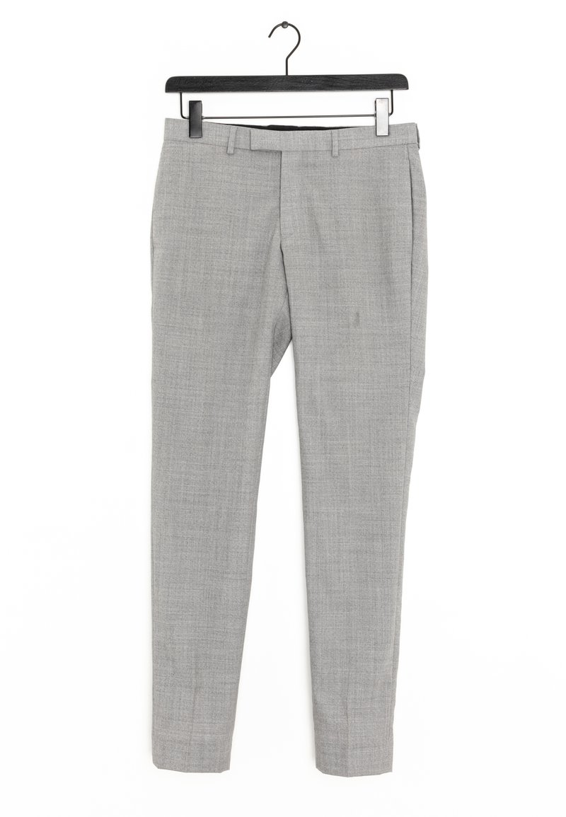 Pantalon sur mesure gris clair avec passants de ceinture et poches avant suspendu à un cintre noir sur fond blanc.