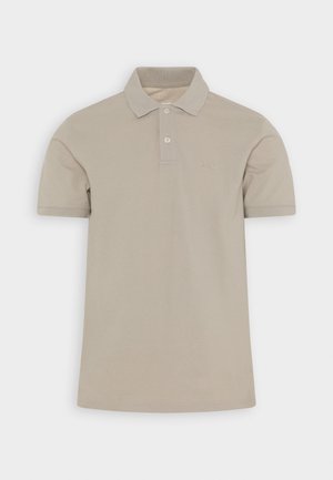 Polo shirt beige à manches courtes en coton avec un col, deux boutons et un logo brodé ton sur ton sur la poitrine gauche. Texture lisse.