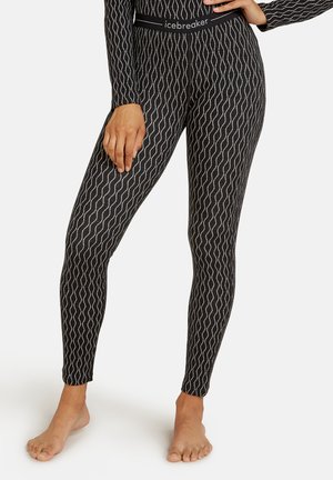 Black leggings with white wavy pattern, featuring a fitted design and a smooth texture. Elastic waistband with "icebreaker" branding.