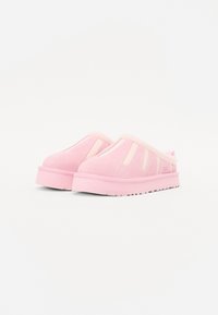 Rosa mockaskinnstoppar med en bred tåbox, utklippta sidopaneler och en tjock gummisula. Har en strukturerad yta och kontrasterande rosa detaljer.