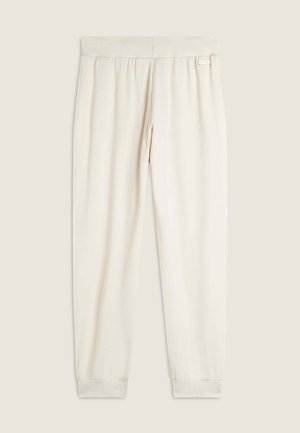 Joggers color crema realizzati in tessuto morbido, dotati di una cintura elastica e orli arricciati. Include un piccolo tag con logo sulla cintura.