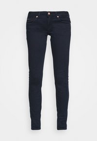Jeans ajustados de mezclilla azul marino, con cinco bolsillos, herrajes de cobre y un sutil detalle del logo en el bolsillo trasero.