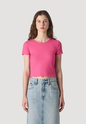 Rosa ribbet crop top med korte, bølgete ermer og rund hals, parret med et lys blått denimskjørt med høy midje.