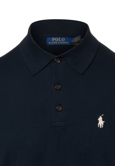 Polo en maille de couleur bleu marine de Polo Ralph Lauren avec trois boutons et logo brodé blanc du joueur de polo sur la poitrine.