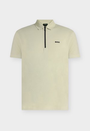 Polo beige clair à manches courtes avec patte zippée et logo noir "BOSS" sur la poitrine gauche.