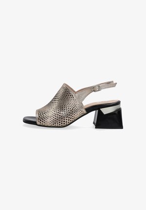 Sandały typu slingback z metaliczną perforowaną cholewką, odkrytym palcem i kontrastującym, geometrycznym czarnym obcasem. Kolorystyka jasnoszara i czarna.