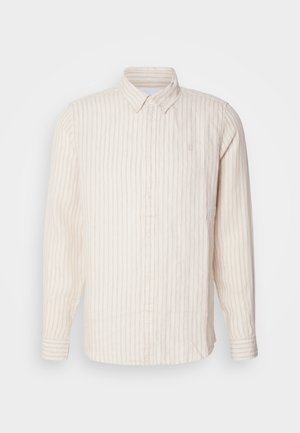 Chemise à boutons rayée en beige clair avec de fines lignes verticales. Elle possède un col et des manches longues, fabriquée à partir d'un tissu texturé.