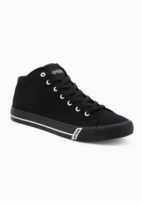 Zapatillas altas negras de material de lona, con puntera redonda, ojales blancos y una franja blanca a lo largo de la suela de goma. Logotipo de la marca en la lengüeta.
