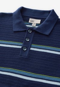 Tricou polo bleumarin cu o textură tricotată, având trei nasturi și dungi orizontale în albastru deschis și verde. Etichetă vizibilă în interiorul gulerului.