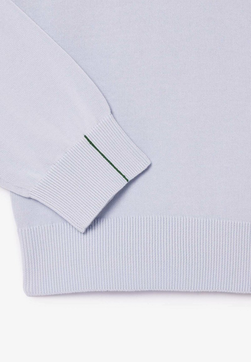 Hellblauer Strickpullover mit gerippten Bündchen und Saum, ausgestattet mit einem grünen Akzentstich an den Bündchen für besondere Details.