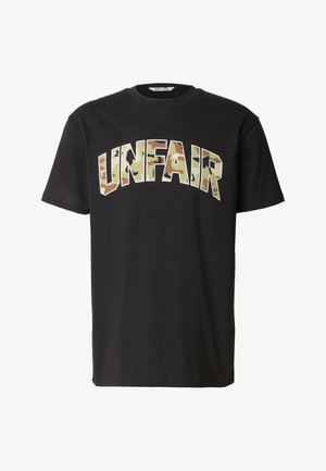 Schwarzes T-Shirt mit kurzen Ärmeln und auffälligen Buchstaben im Tarnmuster, die "UNFAIR" über die Brust buchstabieren.