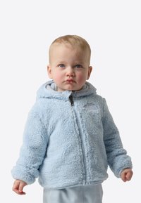 Jachetă din fleece albastru deschis cu suprafață texturată și pufoasă, cu închidere frontală cu fermoar, glugă cu șnur și un logo pe pieptul stâng.