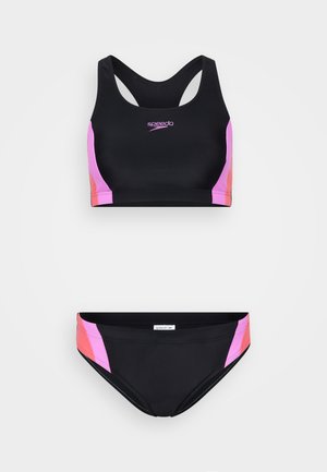 Tvådelad baddräkt med en svart topp med rosa detaljer och logotyp, samt matchande svarta underdelar med rosa sidopaneler. Tillverkad av mjukt, elastiskt material.