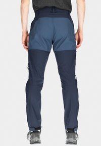 Marinblå utomhusbyxor med en kontrasterande ljusblå panel, elastisk midja, fickor med dragkedja och ankelmanschetter. Tillverkade av slitstarkt tyg.