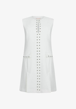 Rochie albă fără mâneci, cu rânduri verticale de ținte metalice pe față, două buzunare cu clapetă cu ținte și un mic decolteu frontal în formă de cheie.