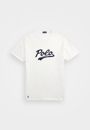 Balta medvilninė marškinėliai su dideliu tamsiai mėlynu "Polo" logotipu ir mažesniu "Ralph Lauren" tekstu po juo, o apatine dalimi puošia tamsiai mėlynas siuvinėtas logotipas.