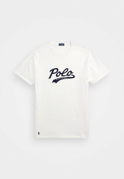 T-shirt en coton blanc avec un grand logo « Polo » bleu marine et un texte « Ralph Lauren » plus petit en dessous, accompagné d'un logo brodé bleu marine sur l'ourlet.