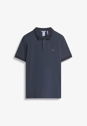 Camiseta polo de color navy con cuello acanalado, mangas cortas y un parche de logo texturizado. Tejido suave con un ajuste clásico y dobladillo plano.