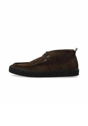 Bottes chukka en suede marron avec un bout arrondi, des œillets gris et une semelle en caoutchouc noir texturé. Système de laçage à l'avant et une languette à l'arrière.
