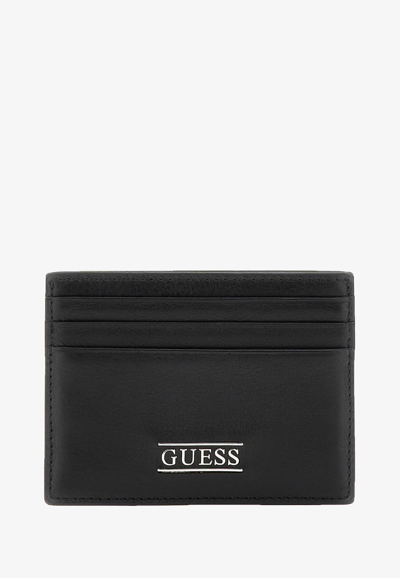 Black leather cardholder featuring four slots, textured finish, and silver "GUESS" logo accent on the front. Smooth edges and minimalist design.