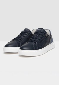 Baskets en cuir marine avec semelle en caoutchouc blanche, bout arrondi, lacets plats et détail de zip sur le côté. Comprend des accents texturés et un logo sur la languette.