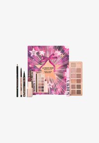 Coffret de maquillage avec un packaging rose et violet, présenté avec un nœud et des graphiques d'étoiles. Comprend une palette de fards à paupières, un eyeliner, un gloss à lèvres et des crayons.