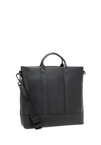 Mustan nahkakassin rakenne on selkeä, ja siinä on kaksi yläkahvaa sekä irrotettava olkahihna. Kassi on sileäpintainen ja siinä on minimaalinen varustus.