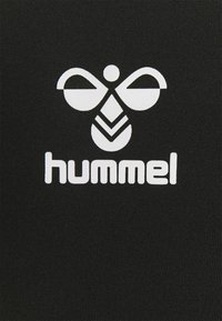 Tessuto nero con un grande logo bianco che presenta un design astratto di un'ape e la parola "hummel" in lettere semplici e in grassetto sottostante.