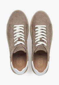 Brązowe zamszowe sneakersy z białymi sznurówkami i białym akcentem na pięcie. Posiadają okrągły czubek i teksturowaną gumową podeszwę dla lepszej przyczepności.