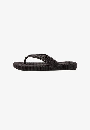 Black flip-flop made of textured rubber, featuring a perforated strap and a patterned footbed for grip. Flat sole with thin apex.