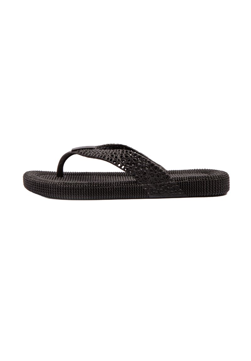 Chancla negra hecha de goma texturizada, con una correa perforada y una plantilla estampada para mayor agarre. Suela plana con un pico delgado.