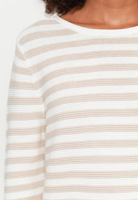Gestreifter Strickpullover mit abwechselnd weißen und beigen horizontalen Linien, strukturiertem Stoff und rundem Ausschnitt.