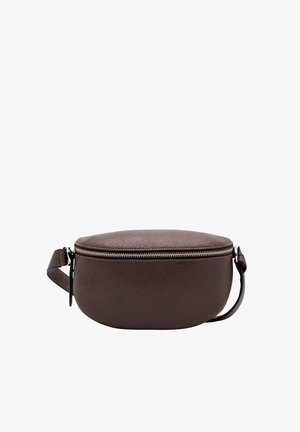 Jeune femme aux longs cheveux bruns portant un t-shirt noir à manches longues et un grand sac bandoulière en cuir marron foncé avec une fermeture éclair.
