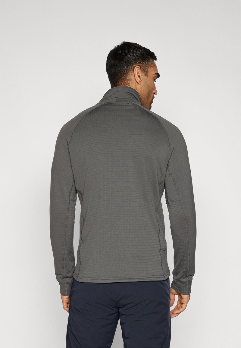 Szary, długi sweter z wysokim kołnierzem, o prążkowanej fakturze i dopasowanym kroju. Posiada rękawy raglanowe i gładkie szwy.