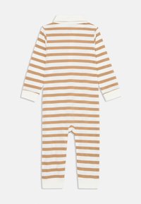 Randig onepiece i beige och vitt, med långa ärmar, krage och ribbade muddar vid handleder och anklar. Mjuk bomullsmaterial.
