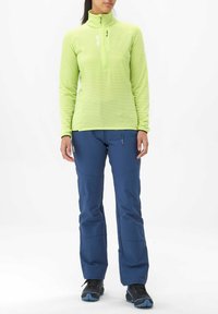 Haut en polaire léger vert clair à zip jusqu'au quart avec un motif en grille texturé, associé à un pantalon softshell bleu marine doux avec une poche latérale et des coutures de renfort.