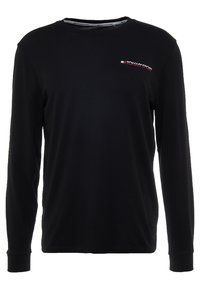 Černé dlouhé rukávy tričko vyrobené z bavlny, s kulatým výstřihem a malým červenobílým logem "TOMMY SPORT" na hrudi.