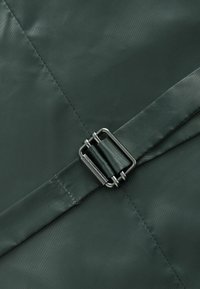 Dunkelgrüne Nylon-Tasche mit einer strukturierten Oberfläche, gesichert mit einer metallischen Schnalle. Klare Linien und keine sichtbaren Muster oder zusätzlichen Akzente.