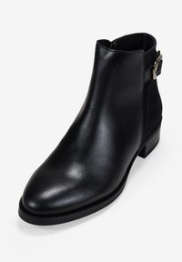 Botín negro de cuero suave con punta afilada, detalle de hebilla lateral y tacón bajo cuadrado. Paneles de ante en los laterales.