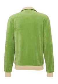 Zöld velúr dzseki puha textúrával, hosszú ujjakkal és bézs bordás gallérral, valamint szegéllyel. Nincsenek látható fémalkatrészek vagy minták.