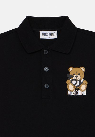 Čierna polokošeľa vyrobená z bavlny, s grafikou medveďa na ľavej hrudi a bielym textom "Moschino". Trojité zapínanie na gombíky pri krku.