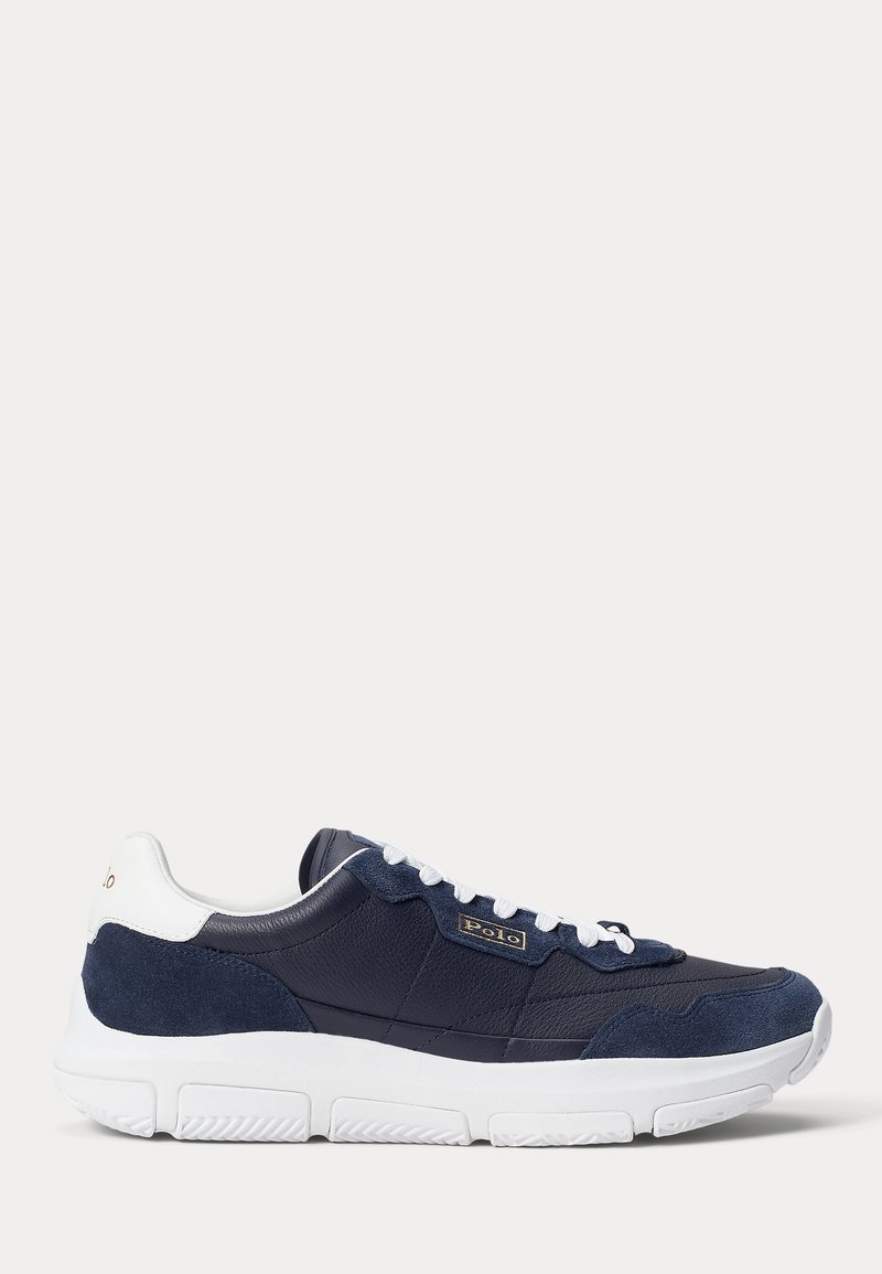 Baskets Polo bleu marine et blanc avec tige en cuir et daim, lacets blancs et semelle extérieure épaisse en caoutchouc blanc, vue de côté.