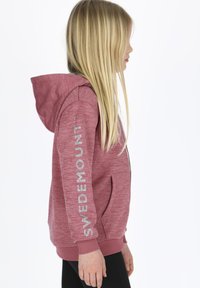 Rosa huvtröja med dragkedja och en logo tryckt i silver längs vänster ärm. Ribbad mudd och nederkant, tillverkad av mjukt material.