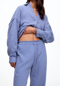 Ljusblå, texturerad bomullsskjorta med knäppning, krage och sänkta axlar, i kombination med matchande byxor med dragsko.